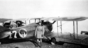 Man poses beside a airplane during world war