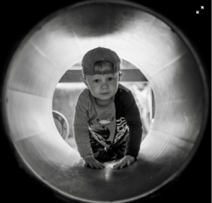 Kid crawls inside the cylindrical structure