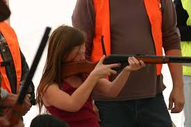Girl aims a gun at a firing range