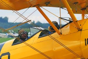 People flying in a yellow airplane