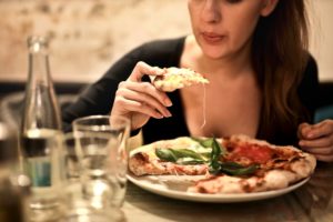 Woman eats a pizza